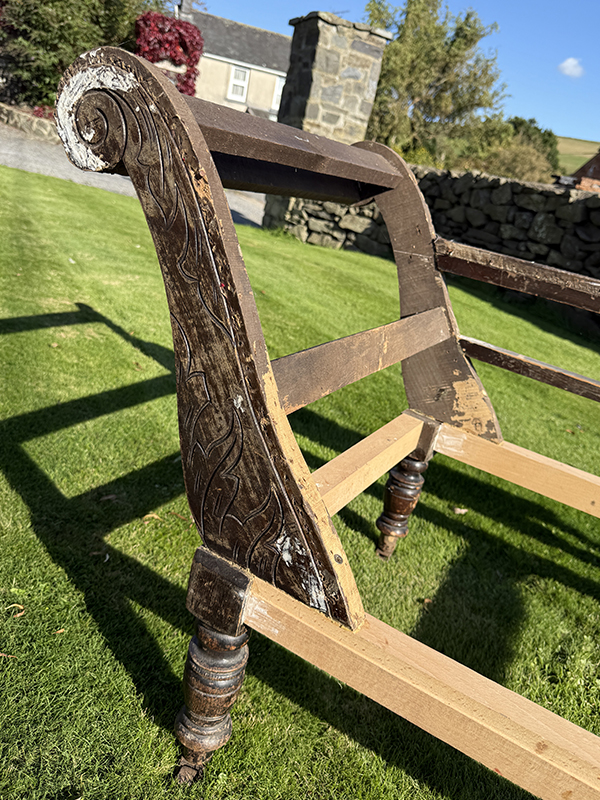 Detailed carvings on antique chaise longue back
