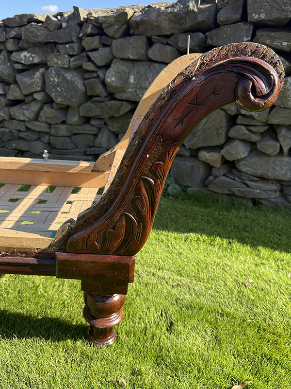 Detailed carvings on a chaise longue frame back