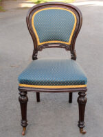 A mahogany traditionally upholstered balloon back dining chair with back pads, blue upholstery and gold braid.